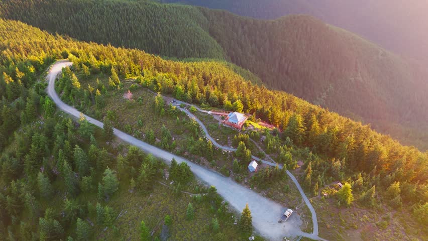 Aerial view tilting up from the Suntop Fire Lookout to reveal Mount Rainier at sunset, Washington State.