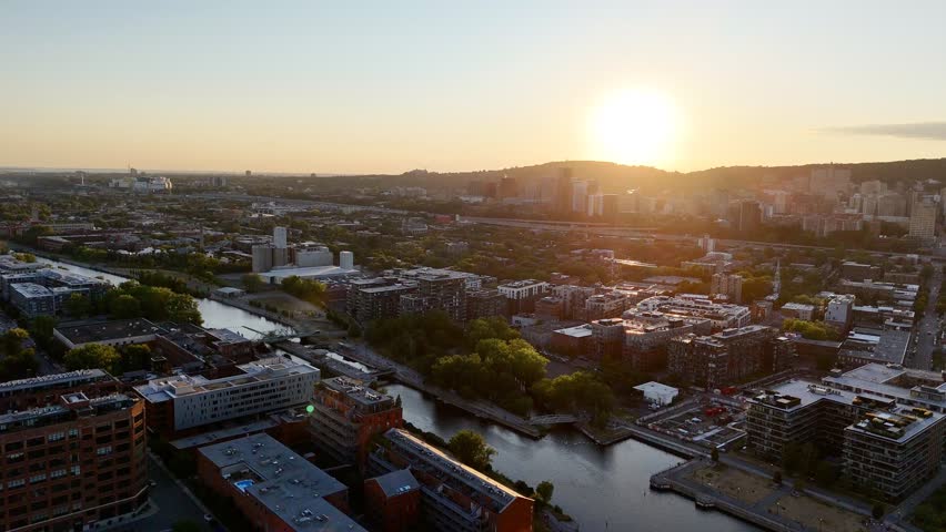 Aerial view of modern waterfront district with high-rise buildings and riverside paths, Montreal twilight skyline. g.