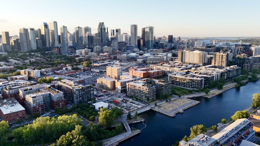 Aerial view of modern waterfront district with high-rise buildings and riverside paths, Montreal twilight skyline. g.
