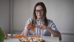 Woman peeling carrot at kitchen table, meal preparation, home cooking, healthy lifestyle - Powered by Shutterstock - Get 15% off with code: PIKWIZARD15