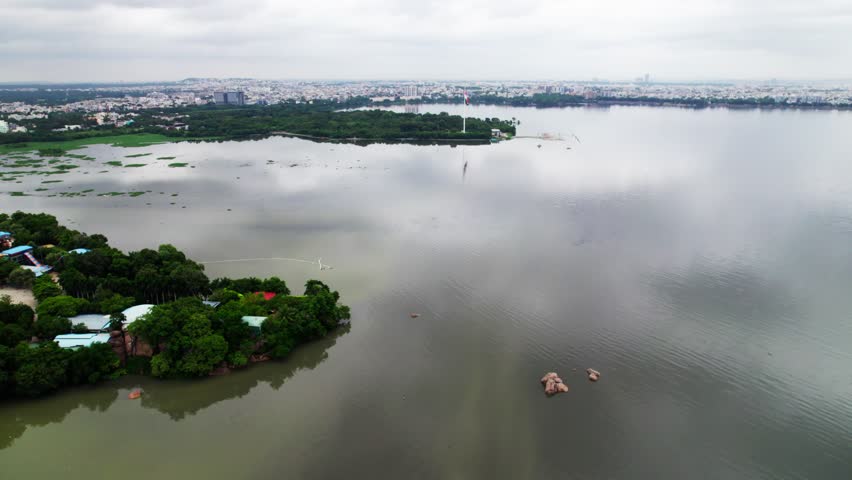 Aerial view of hussain sagar lake with Sanjeevaiah Park and hyderabad cityscape. day time, parallax shot, drone shot, 4k.