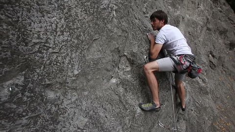 Young man rock climbing on a big natural rock