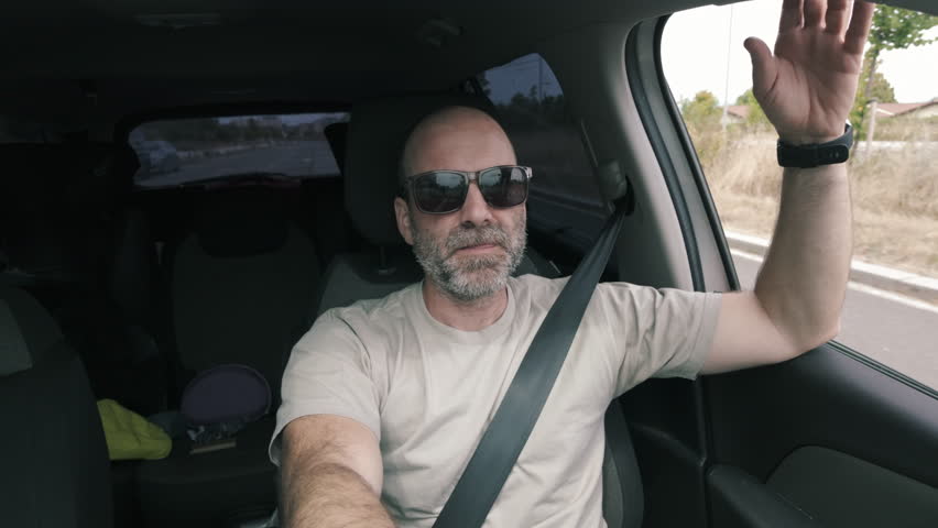 Man driving a car, interior dashcam view.