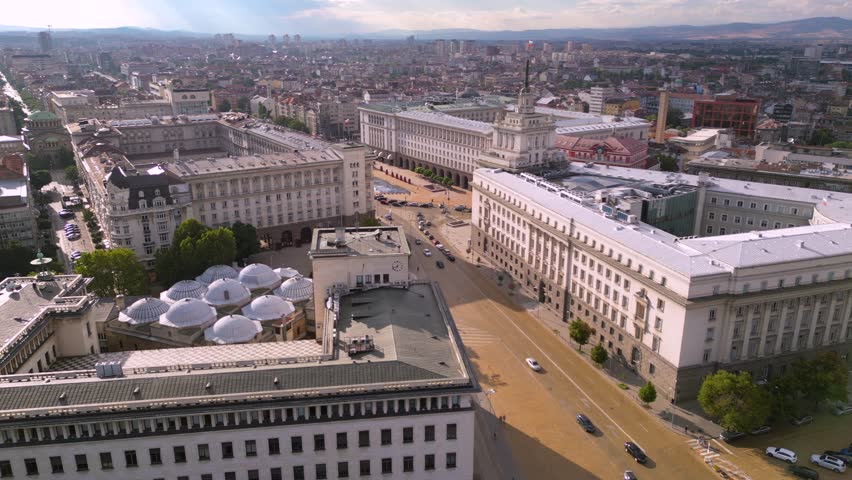 Aerial footage of the yellow brick road of the city center of Sofia. Drone shot of the largo Bulgarian capital national assembly parliament and presidential buildings seen from above during sunset. 