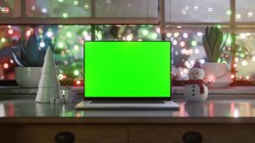Laptop with green screen, camera zoom-in, and static seamless loop at the last 200 frames of the clip. Falling snow and festive Christmas lights, luma matte and tracking layer included - Powered by Shutterstock - Get 15% off with code: PIKWIZARD15