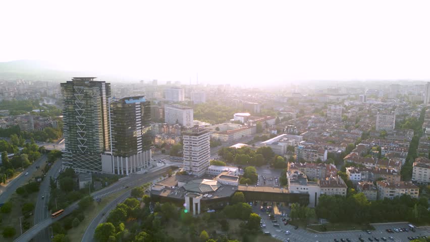 Aerial footage of the city center of Sofia Bulgaria on a warm summer afternoon. National Palace of Culture seen from above during sunset. Milennium center and parks visible from a helicopter.