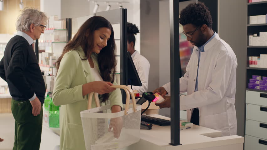 Medicine buying customers in pharmacy multiracial African Indian people shopping pills vitamins drugs pharmacists professional help at cashier counter sell health care products clients in drugstore