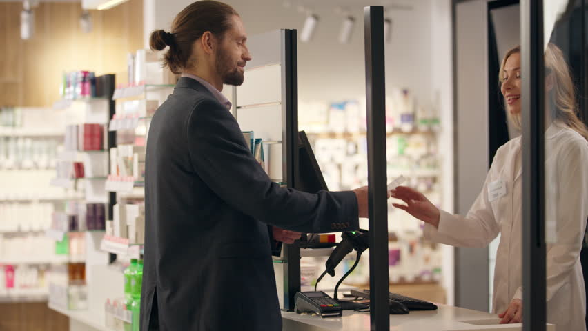 Medication order in pharmacy man customer buying pills drugs woman pharmacist seller help medical prescription purchase give package health care medicine buy at cashier counter shopping in drugstore