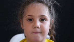 Closeup girl making pouting facial expression, child face fills frame with eye contact and subtle smile shift, portrait captures emotion and playful mood, closeup view of eyes cheek and lip movement - Powered by Shutterstock - Get 15% off with code: PIKWIZARD15