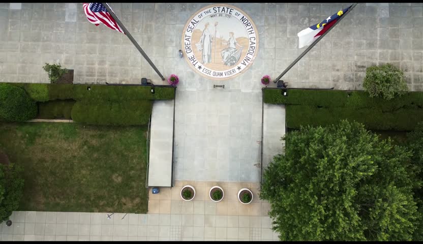 Aerial view of the NC State Legislature building with the North Carolina state seal and flag