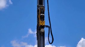 A towering drilling rig framed against a clear blue sky with fluffy clouds, showcasing industrial machinery. - Powered by Shutterstock - Get 15% off with code: PIKWIZARD15