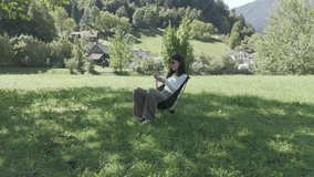 Young woman sitting in a chair on a meadow by the river, enjoying ice cream on a sunny day, relaxing outdoors, embracing nature, leisure, summer treat and peaceful countryside moment - Powered by Shutterstock - Get 15% off with code: PIKWIZARD15