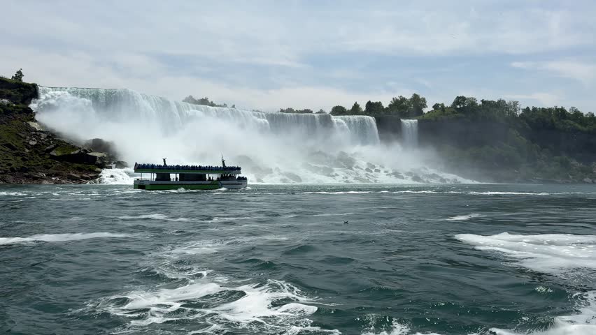 PAN SLOW MO - The American, Bridal Veil, and Horseshoe Falls as seen from the Niagara City Cruises. Niagara Falls is a collective name for a group of three waterfalls situated on the Niagara River.