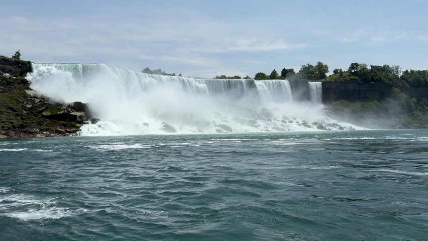 PAN SLOW MO - The American, Bridal Veil, and Horseshoe Falls as seen from the Niagara City Cruises. Niagara Falls is a collective name for a group of three waterfalls situated on the Niagara River.