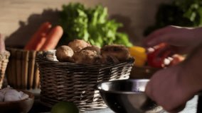 Close up of a hand carefully choosing fresh young potatoes from a rustic basket. A variety of other raw vegetables create a vibrant, healthy market scene. - Powered by Shutterstock - Get 15% off with code: PIKWIZARD15
