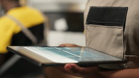 Close up of distribution hub worker overseeing supply chain process for e-commerce. Reviewing logistics and shipping data on tablet, updating tracking labels for order fulfillment. Camera B. - Powered by Shutterstock - Get 15% off with code: PIKWIZARD15