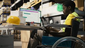 African american wheelchair user works on package tracking info in distribution hub, using awb shipment details to manage express delivery for e-commerce activity. Disability friendly. Camera A. - Powered by Shutterstock - Get 15% off with code: PIKWIZARD15