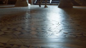 Handheld left-to-right shot of a light-colored mosaic marble floor illuminated by a beam of sunlight coming from the entrance at the end. - Powered by Shutterstock - Get 15% off with code: PIKWIZARD15