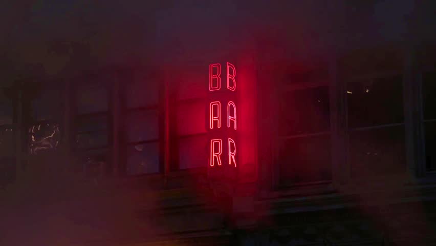 Neon bar sign medium shot . Night exterior video footage of vintage neon sign. A nighttime exterior shot of a generic, unbranded bar and restaurant in street