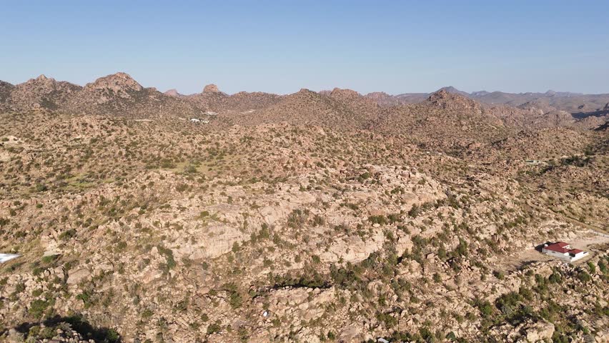 Panoramic drone shot of a wide, dry and rocky landscape in sunny Saudi Arabia