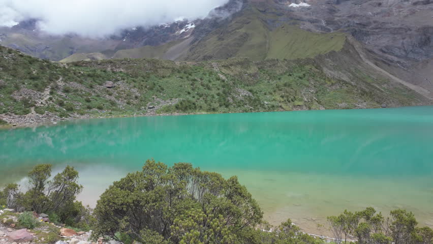 Turquoise Humantay Lake with snow-capped Humantay and Salkantay peaks in slow motion