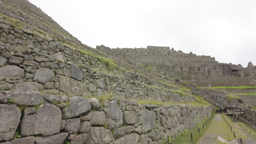 Slow motion video of Inca stone structures inside Machu Picchu, showing ancient walls and architecture in Peru