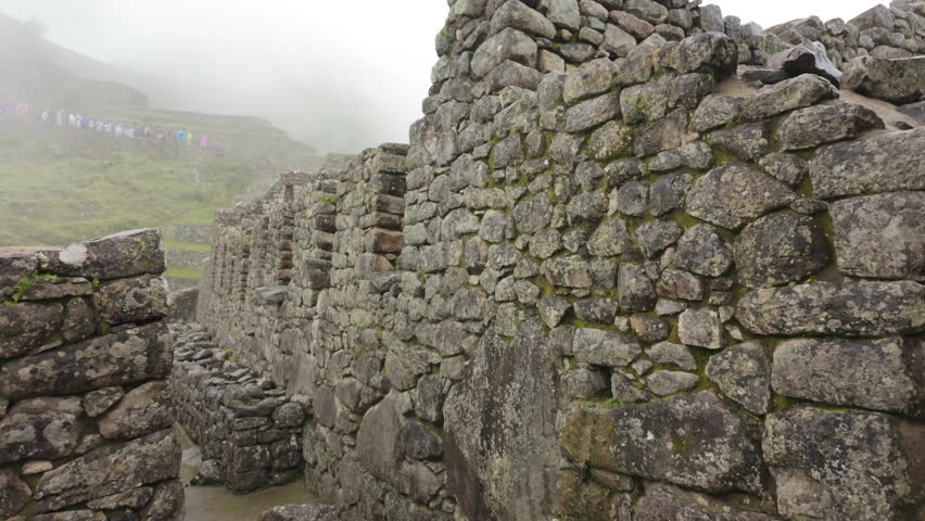 Slow motion video of Inca stone structures inside Machu Picchu, showing ancient walls and architecture in Peru