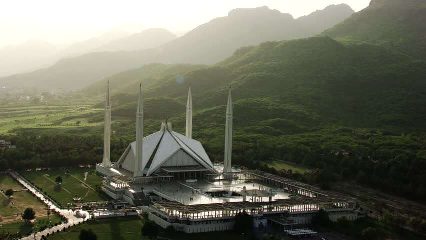 This high-resolution aerial photograph captures the Faisal Mosque, Pakistan’s most iconic religious structure, nestled at the foot of the Margalla Hills in Islamabad.