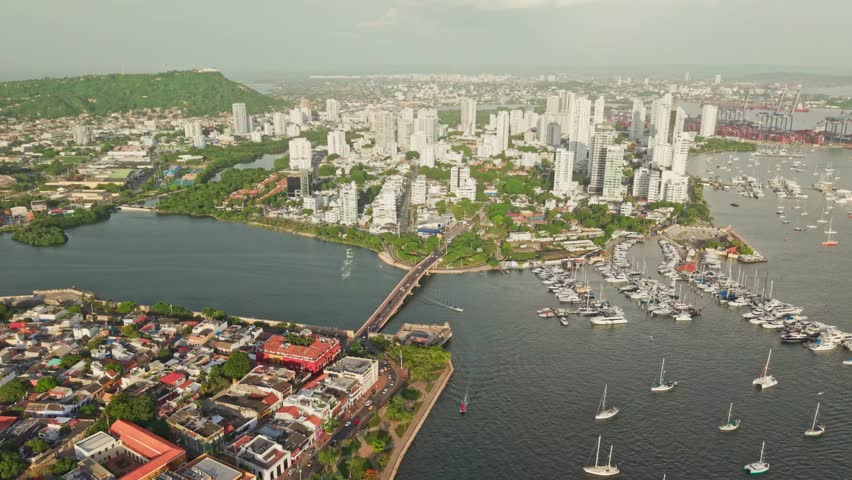 Slow motion aerial view of cartagena, colombia, featuring manga district, a bridge, boats, and the cityscape