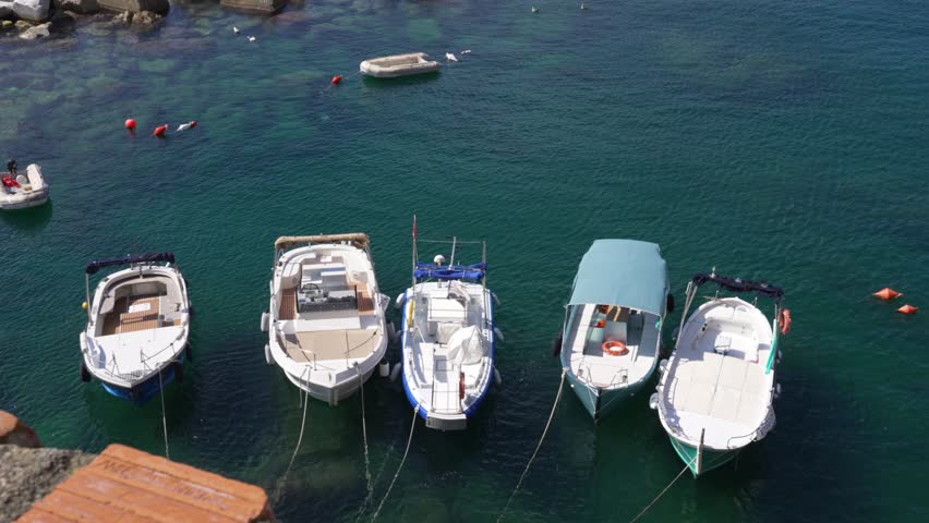 Small boats anchored in clear waters of Cinque Terre, Italy's coastline beauty
