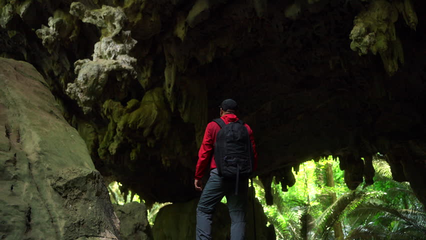 Proud hiker explores cave and forest trail, celebrating success in outdoor adventure, trekking, and nature travel. A true traveller and nature lover on a rewarding journey.
