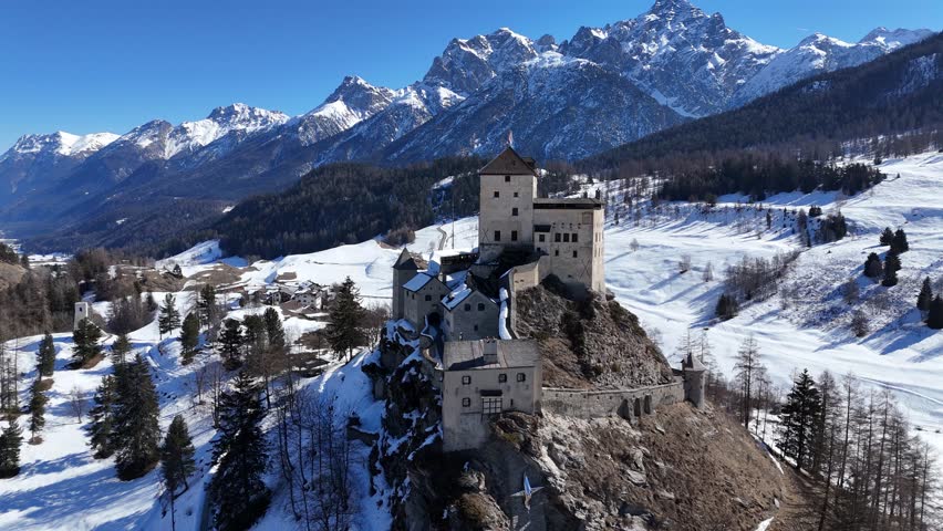 Drone video of Tarasp historic castle in the lower Engadin during Winter in the Swiss Alps of Graubünden, Switzerland