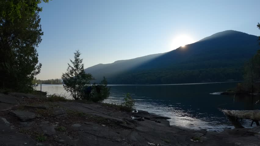 A timelapse of the sun rising and sun rays shining over Black Mountain shot from an Island on Lake George in the Adirondacks in New York State.