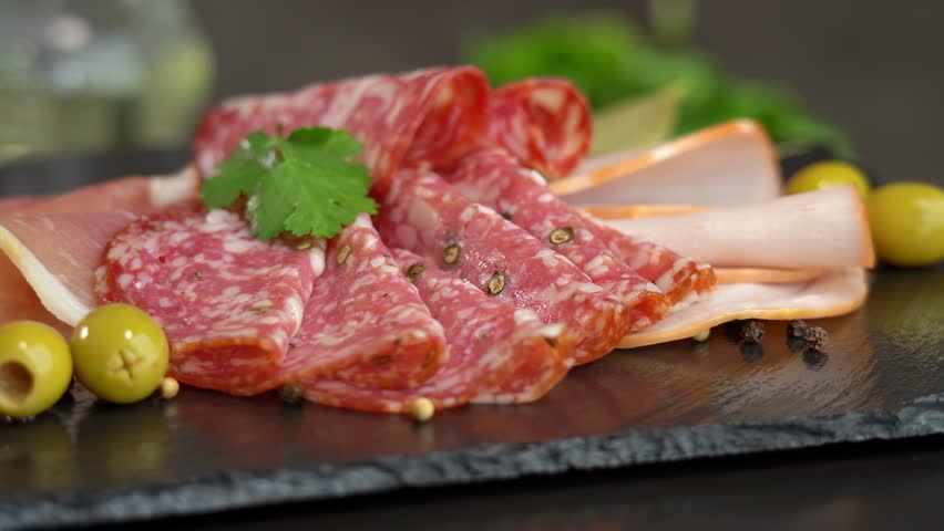 Close up of fresh slices cold cuts sausage ham bacon jamon rotate in circle. Meat. Pork beef. Food