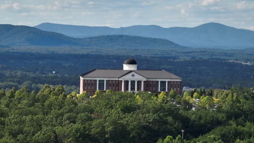 Aerial view of Historic Liberty University College of Osteopathic Medicine in Lynchburg, Virginia. Sunset time on mountains. Sunny day in summer. Red brick buildings and cupola.