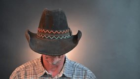 Closeup portrait of a cowboy senior man with his hat in a vintage Harcourt style lighting - Powered by Shutterstock - Get 15% off with code: PIKWIZARD15