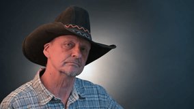 Closeup portrait of a cowboy senior man with his hat in a vintage Harcourt style lighting - Powered by Shutterstock - Get 15% off with code: PIKWIZARD15