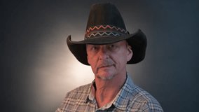 Closeup portrait of a cowboy senior man with his hat in a vintage Harcourt style lighting - Powered by Shutterstock - Get 15% off with code: PIKWIZARD15