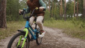 Medium shot of boy cycling diagonally across forest road Symbol of outdoor freedom healthy activity and digital detox away from technology. High quality 4k footage - Powered by Shutterstock - Get 15% off with code: PIKWIZARD15
