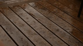 Wooden deck with rainwater dripping from the boards. The deck appears to be wet and slippery, which could be dangerous for people walking on it. Scene is somewhat gloomy and damp - Powered by Shutterstock - Get 15% off with code: PIKWIZARD15