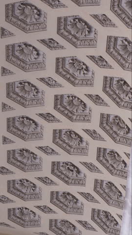 Intricate coffered ceiling with floral reliefs and geometric recessed panels in marble neoclassical interior architecture