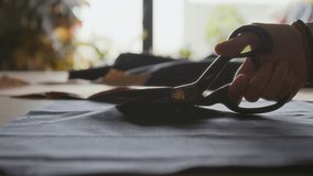 Hand of Seamstress Cutting Pattern from Black Cloth with Scissors - Powered by Shutterstock - Get 15% off with code: PIKWIZARD15
