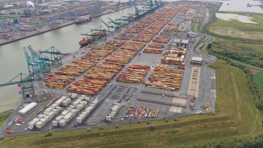 Aerial drone view of Antwerp port cranes unloading vessels at container docks, Belgium
