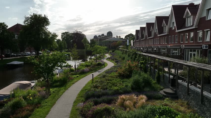 Aerial zoom in highlighting a garden pathway leading to Leiden Observatory with the cityscape in the background, Netherlands.