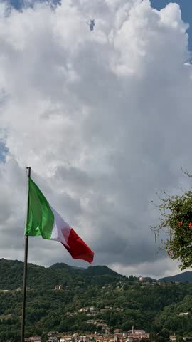 Italian flag during a windy day and mountains
