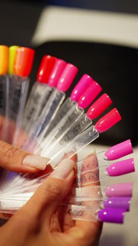 Client chooses color for manicure. Beauty procedures in salon nail care. High quality 4k footage
