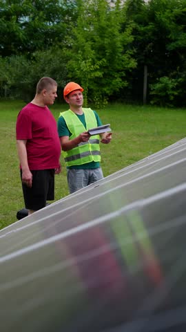 Engineer shows client how to control solar panels via tablet. Environmental protection ecological sources of electricity. High quality 4k footage
