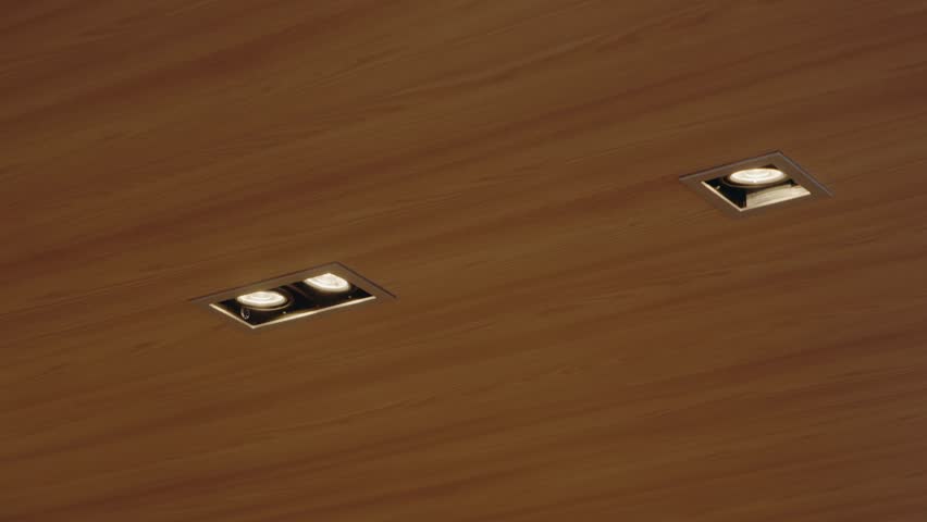 Close-up shot of modern LED ceiling lights embedded in a beautiful wooden ceiling. The warm light illuminates the texture of the wood, creating a cozy atmosphere. architectural, interior design,