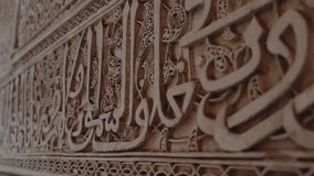 Close-up of intricate Islamic calligraphy carved into a wall. The ornate design showcases the rich artistic heritage of Moroccan architecture. Intricate Islamic Calligraphy Carved - Powered by Shutterstock - Get 15% off with code: PIKWIZARD15