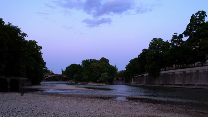 4K Aerial Drone video of a quiet early morning in Munich city center overlooking St Lukas church, Isar river, Marienplatz and the Angel of Peace Friedensengel. Beautiful skyline at a purple sunrise